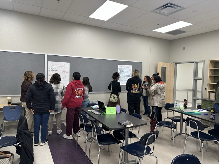 teachers discussing posters made by colleagues 