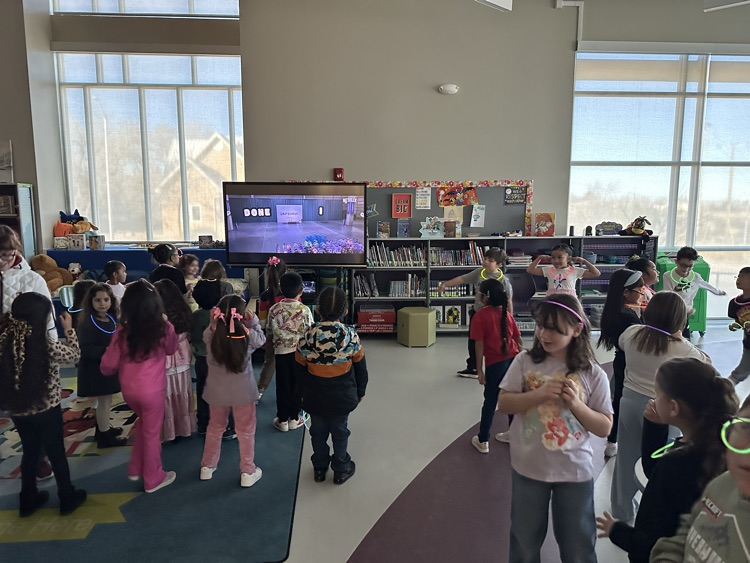 students wearing glow necklaces and glow glasses dancing 