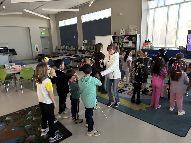 students wearing glow necklaces and glow glasses dancing