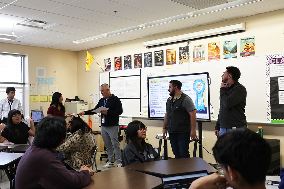 Miyamura high school principal, Mr.Hartog handing ELA student a reward 