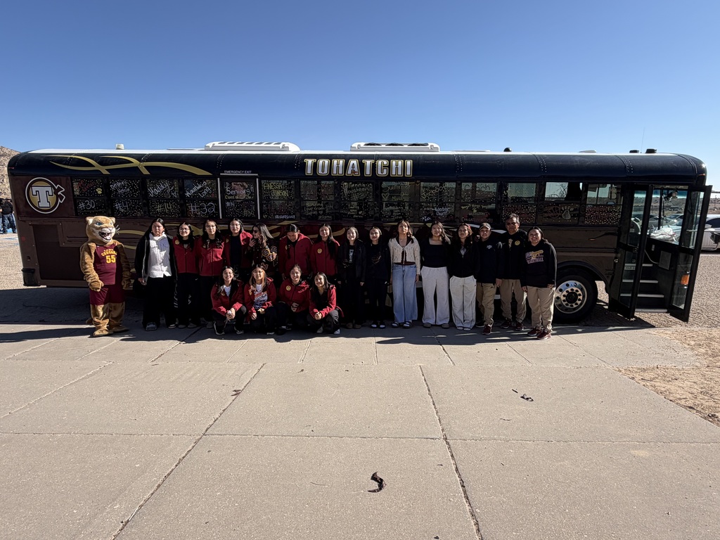 students standing in from of bus