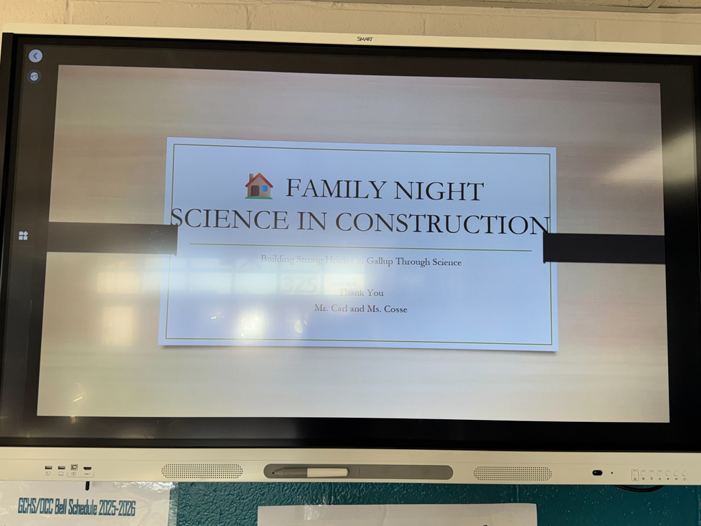 A screen shows a certificate for "Family Night Science in Construction." The background is a plain, light-colored wall.