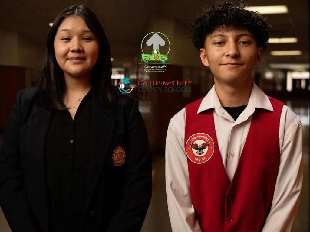Two students pose for a picture. One is wearing a red vest that says "Crownpoint Eagles" the other student is wearing a black blazer with the acronym "H.O.S.A" on it. The McKinley County DWI Prevention Program logo and the Gallup McKinley County Schools logo is in the center of the photo.