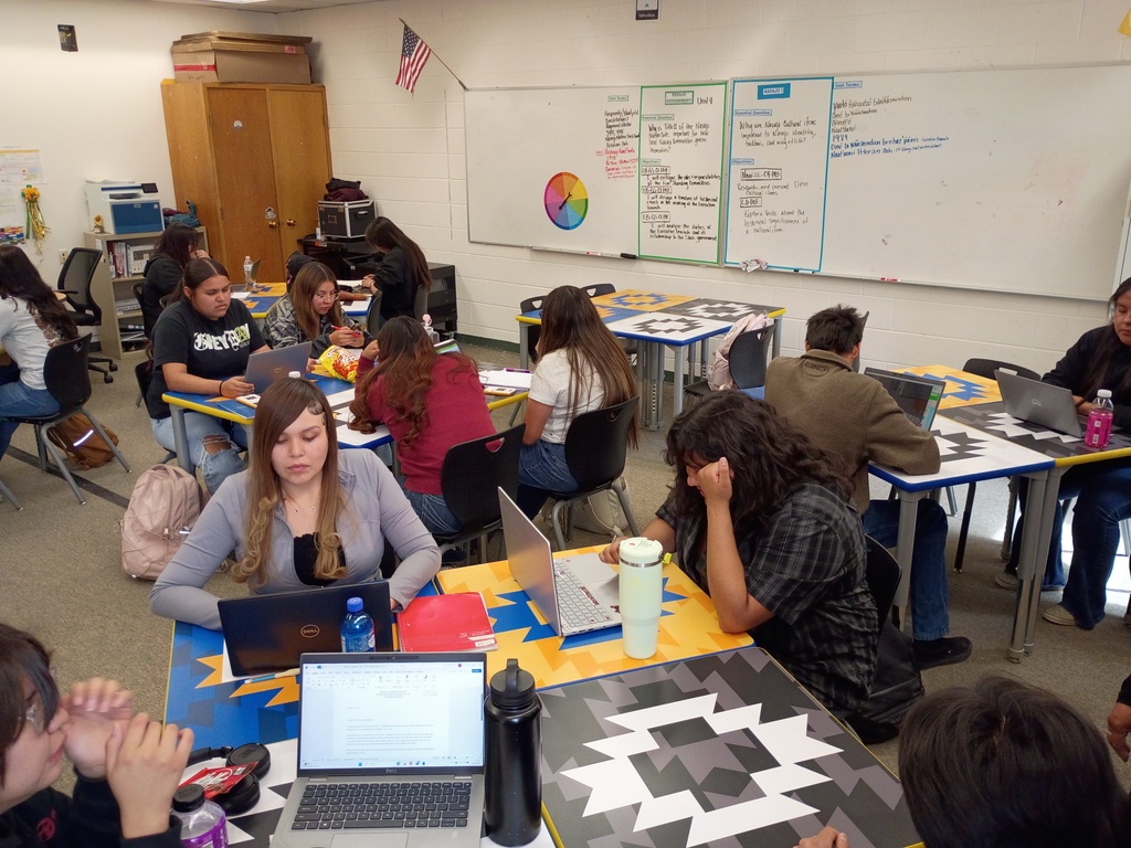 students desk , classroom, gray carpet. yellow, blue, black, and white desks