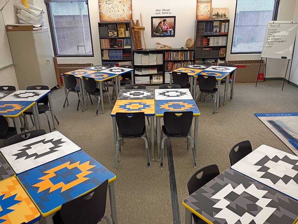 students desk , classroom, gray carpet. yellow, blue, black, and white desks