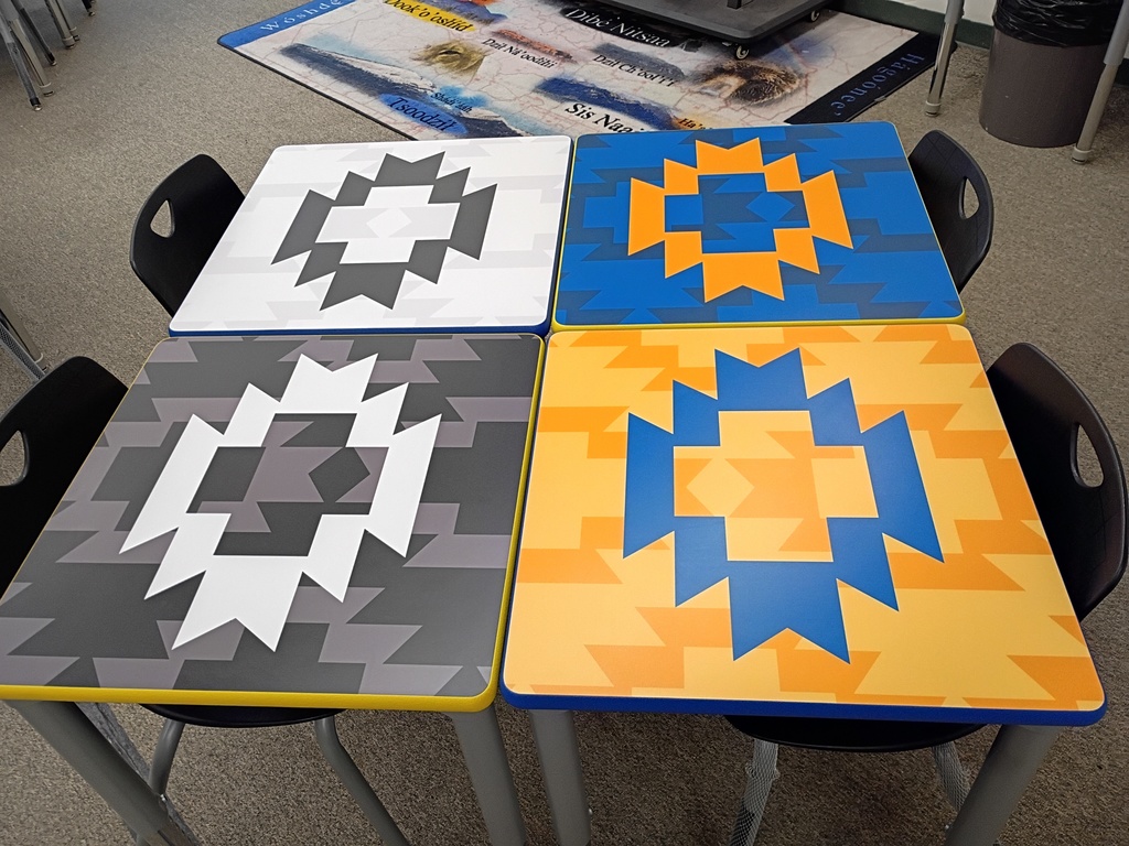students desk , classroom, gray carpet. yellow, blue, black, and white desks