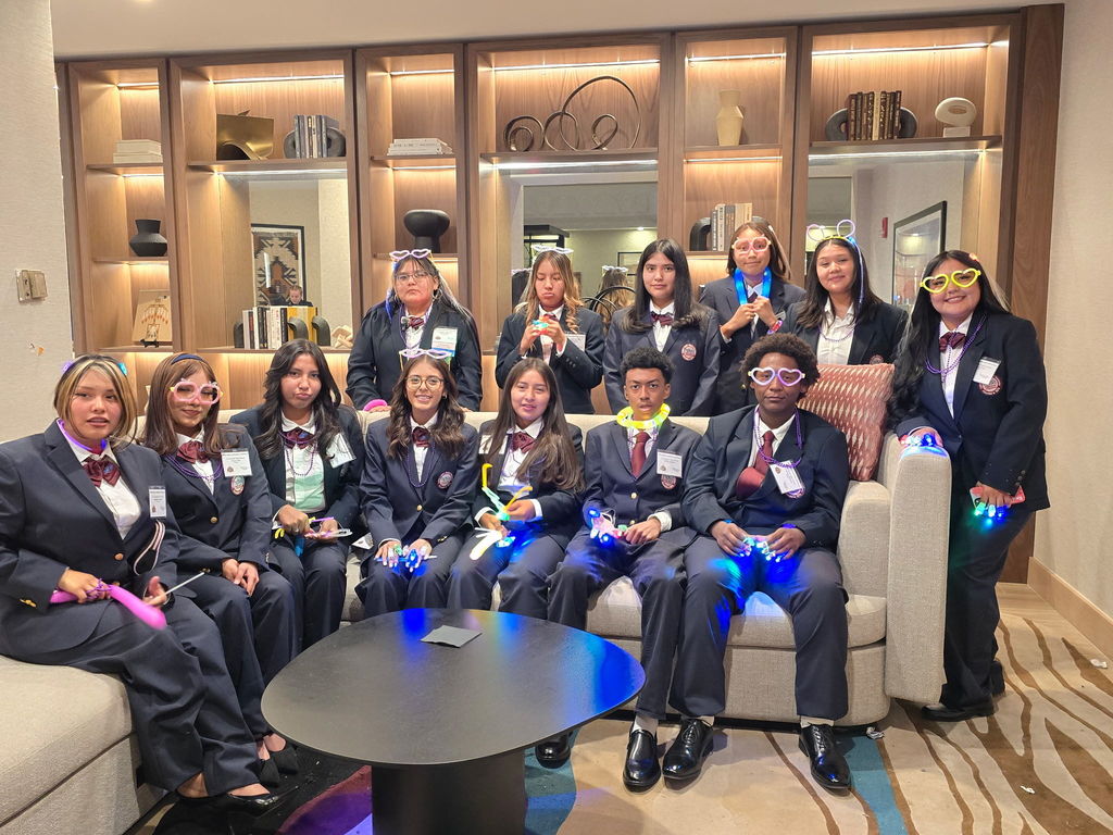 Group of young people dressed in suits and bow ties, posing together for a picture.