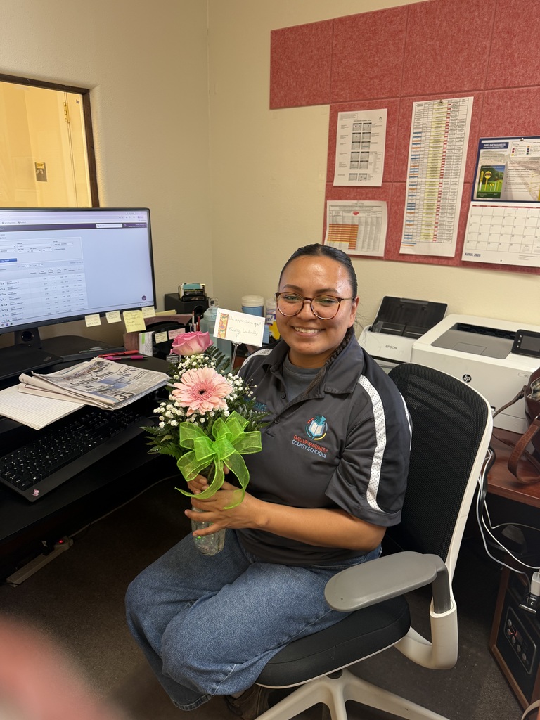 woman sitting down holding a flower arrangement 