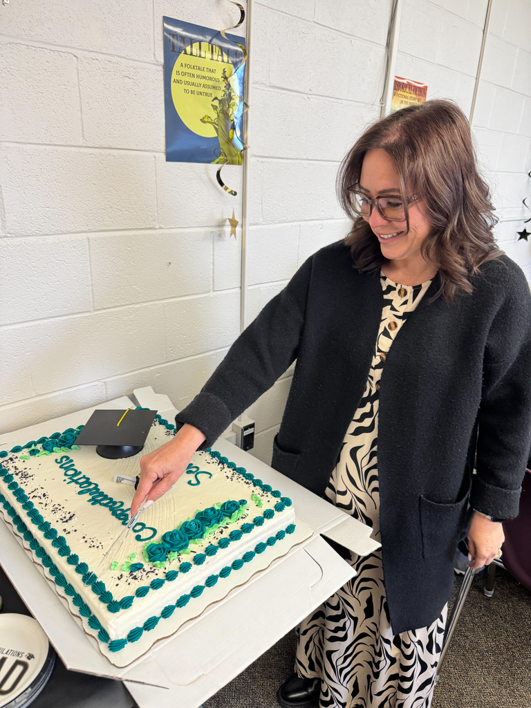 Principal of the school does the honor of cutting the cake for Senior Family night 