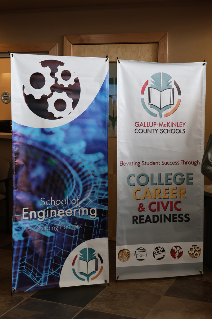 Two banners on tiled floor. One says "School of Engineering" with a blue background. The other says "Gallup-McKinley County Schools" with "College Career & Civic Readiness".