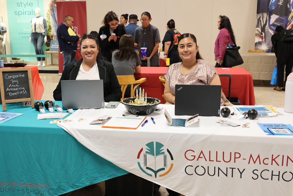 Two people at a booth for Gallup-mCkinley County Schools