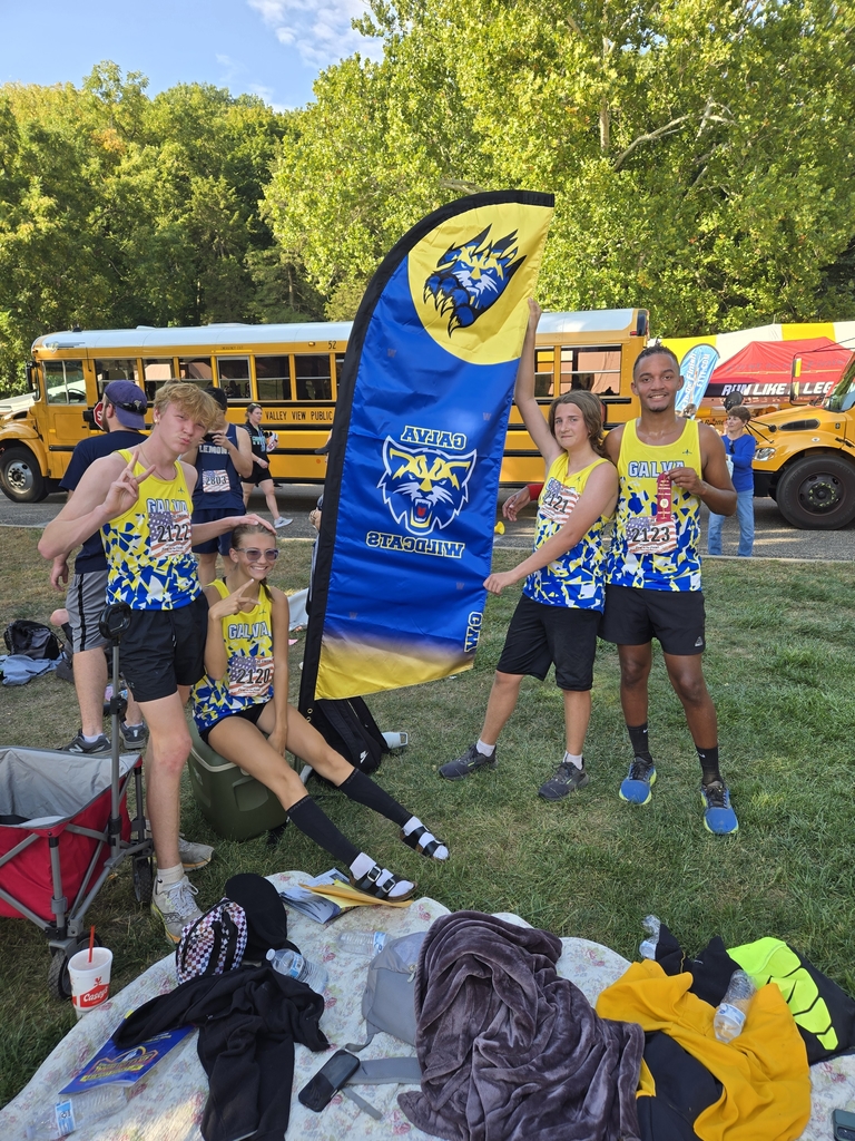 The cross country team posses with their new team flag
