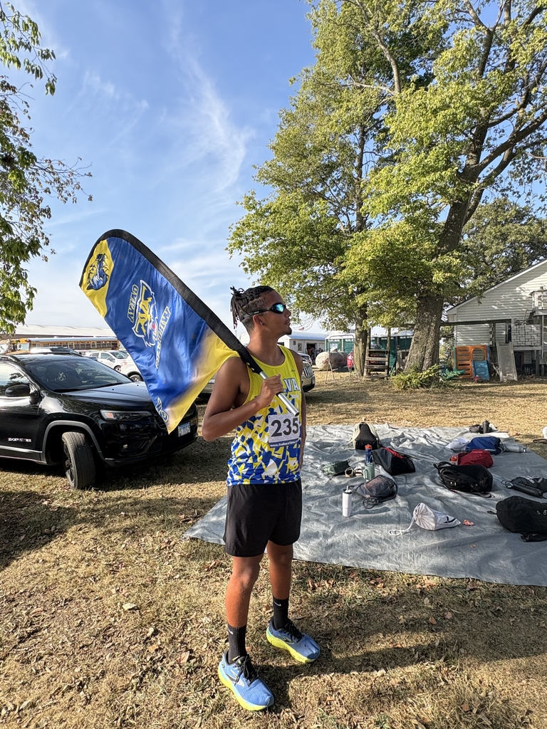 athlete poses with swim goggles on and the team flag
