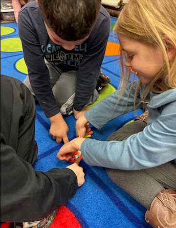 1st grade learning to floss their teeth.