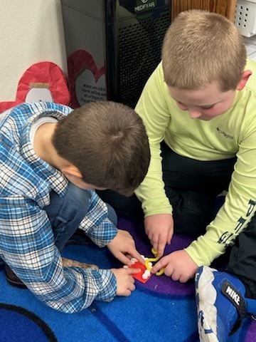Tanner & Hudson working on flossing teeth.