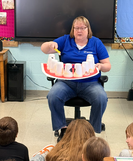 Shelli showing the students how to brush their teeth.