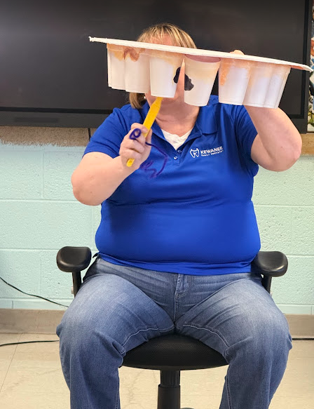 Shelli showing the students how important it is to brush between teeth.