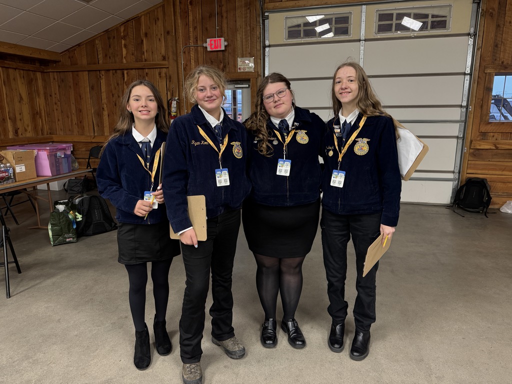Four girls stand for a group photo in their official FFA dress right before competing.