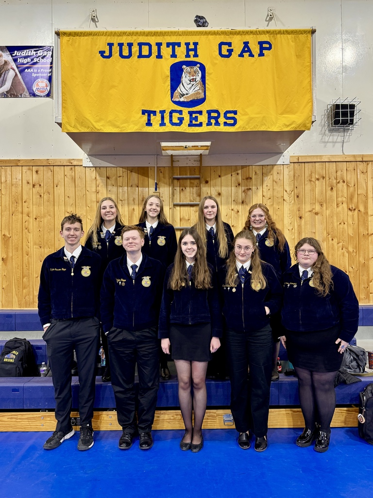 Nine FFA members, wearing official dress, stand together for a group photo after competing in Judith Gap.