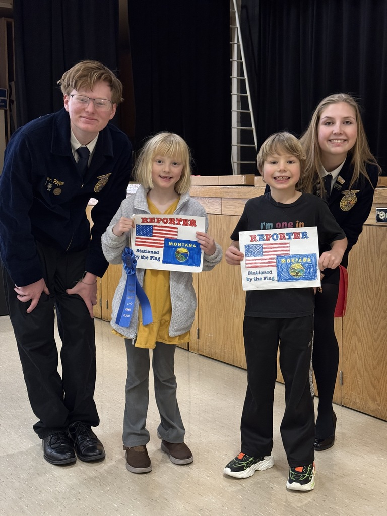 Two of the FFA officers are pictured with elementary students and their coloring pages.