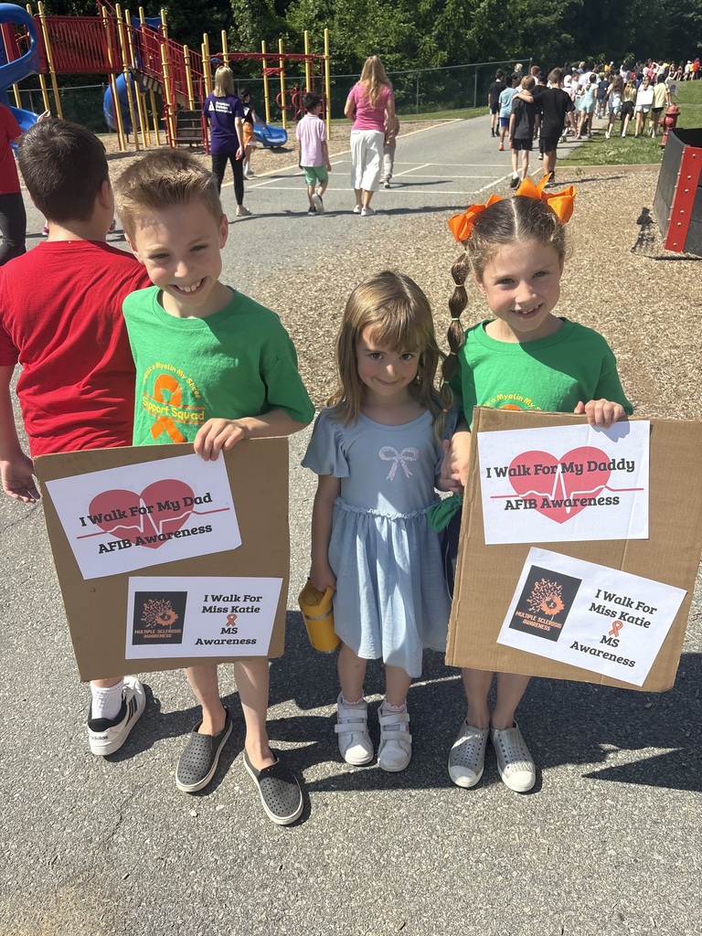 Students smiling holding up signs for causes they support.