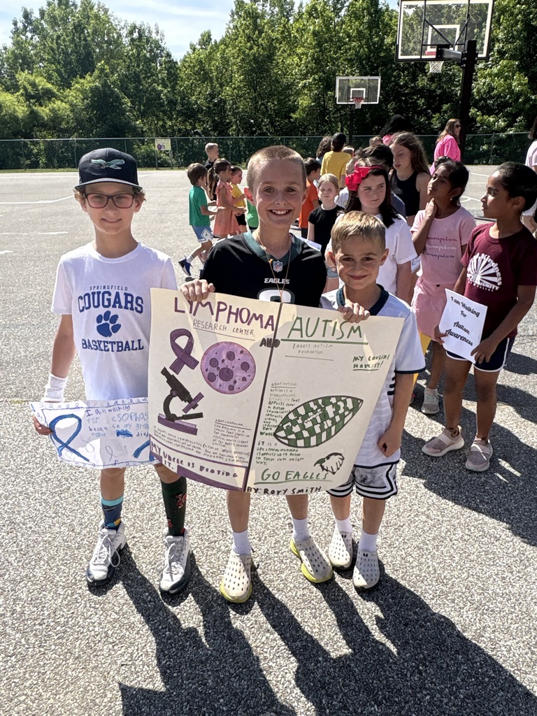 Students smiling holding up signs for causes they support.
