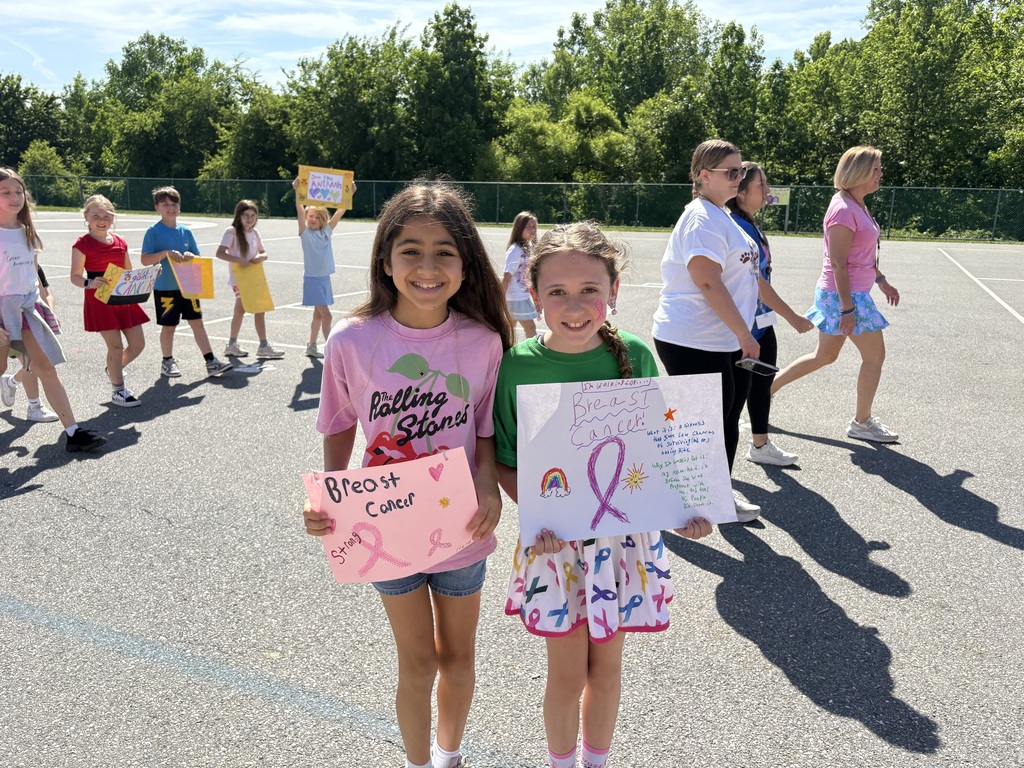 Students smiling holding up signs for causes they support.