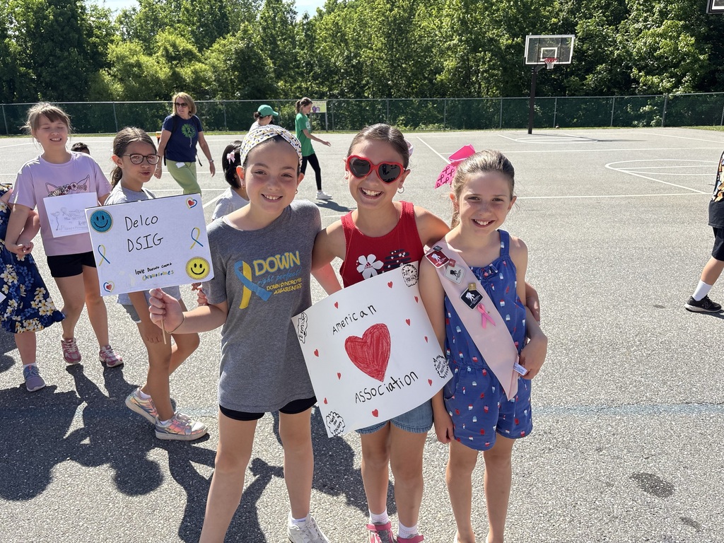 Students smiling holding up signs for causes they support.