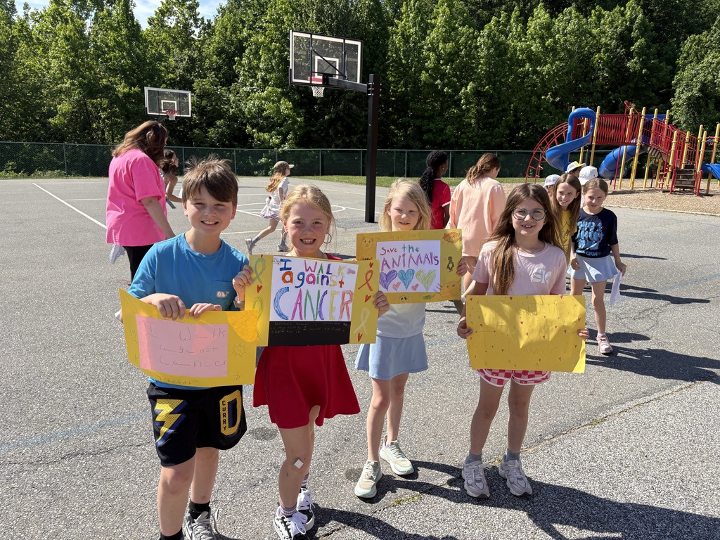 Students smiling holding up signs for causes they support.