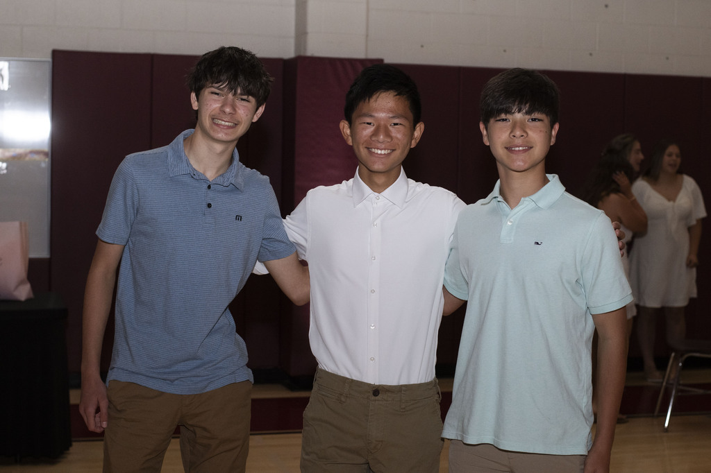 three students posing and smiling