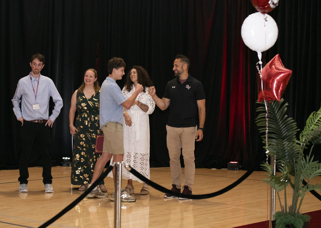 Student fist bumping teacher after receiving diploma