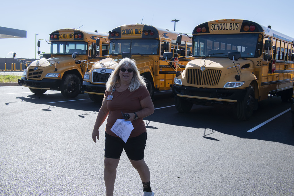 Director of Transportation, Ms Mann, smiling in front of buses
