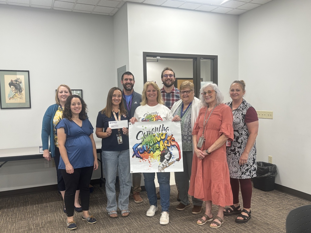 Image of a group of teachers receiving a check from Samantha Funding the Arts.