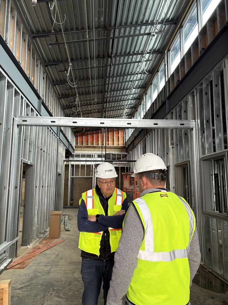 Mr. Glotfelty, Board Vice President, and Mr. Witt, Director of System Operations, discuss renovations in the future entryway of the school.