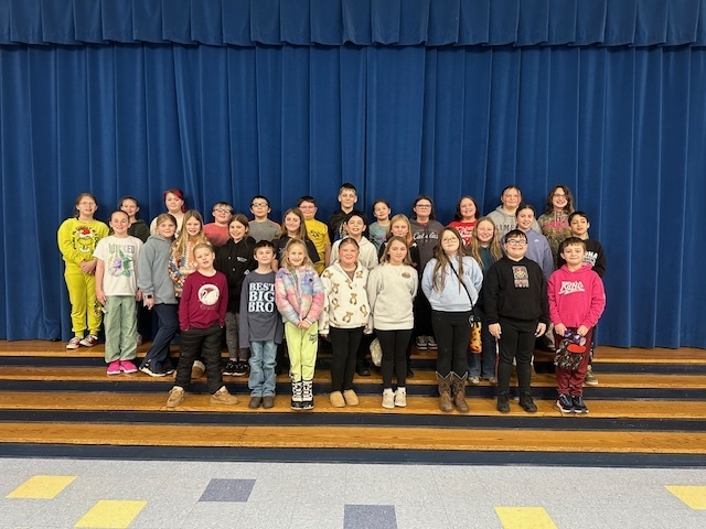 Image of students from Grantsville Elementary, posing together on steps leading to a stage.