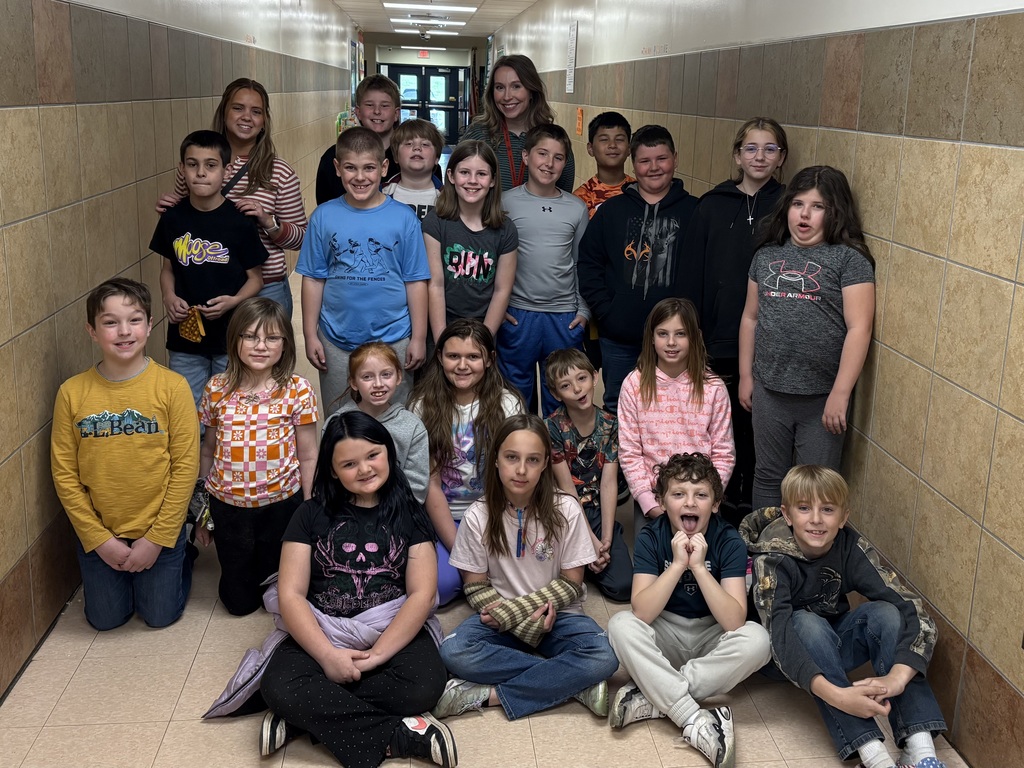 Students from Ms. Friend's class pose together in a school hallway.