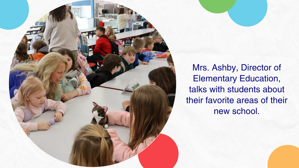 Mrs. Ashby talks to students seated at a table.