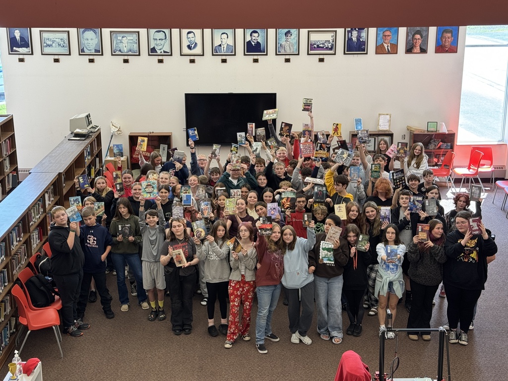 Aerial image of SGHS students posed with their books in the school's media center.