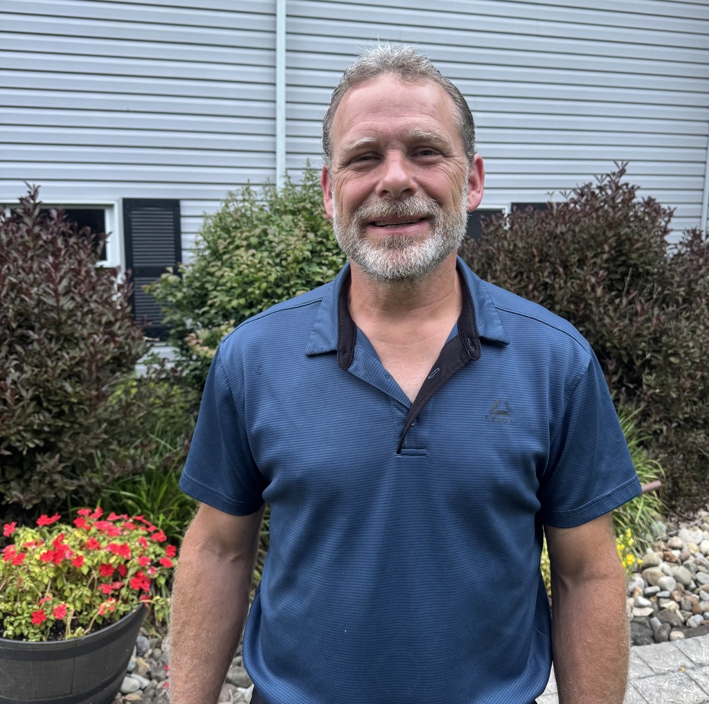 Image of Mr. Friend, posed in front of a flower bed.