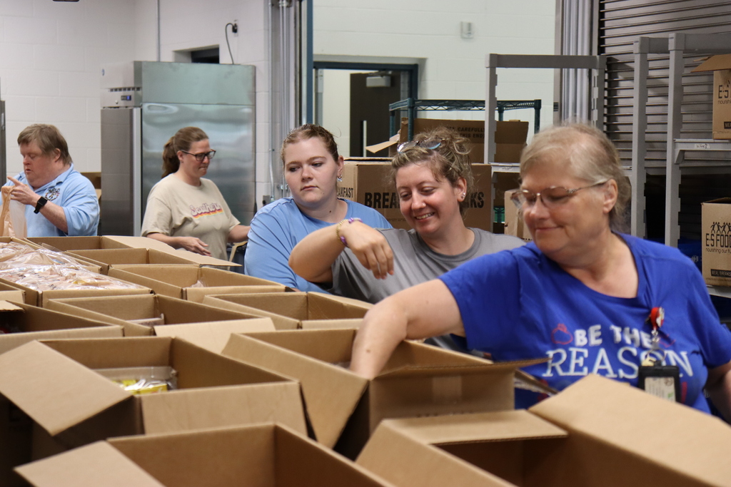 Image of staff members preparing bags for the summer feeding program.