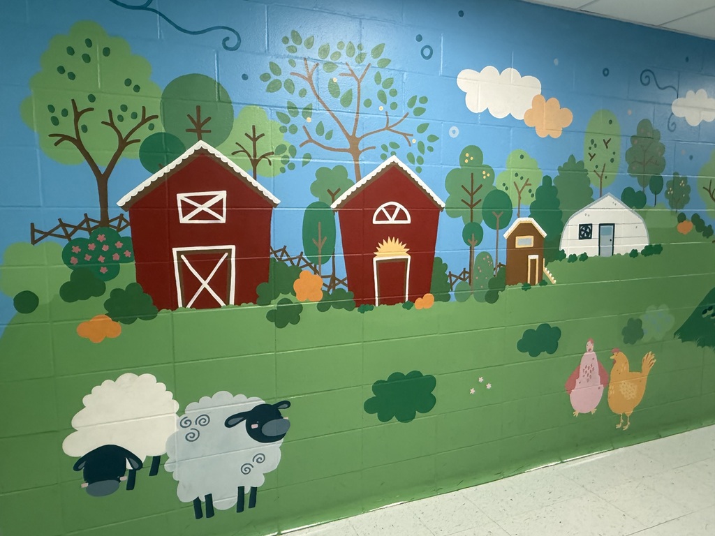 A mural is painted on a wall representing outdoor aspects of Crellin Elementary School. The mural features sheep, chickens, and several barns.