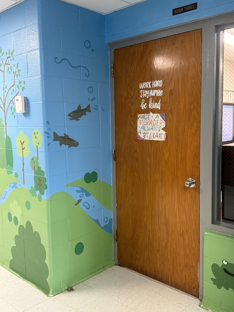 A mural is painted on a wall representing outdoor aspects of Crellin Elementary School. The mural features fish swimming and a frog.