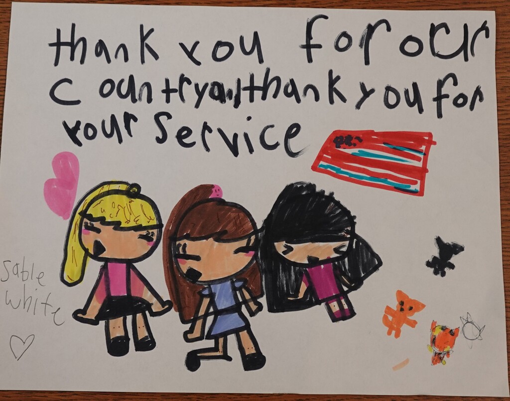 A white card shows a hand-drawn picture of three girls with a message saying "Thank you for your service."