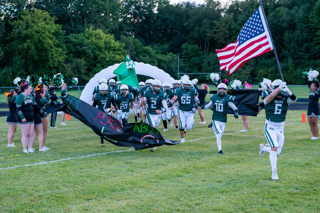 Football players breaking the banner