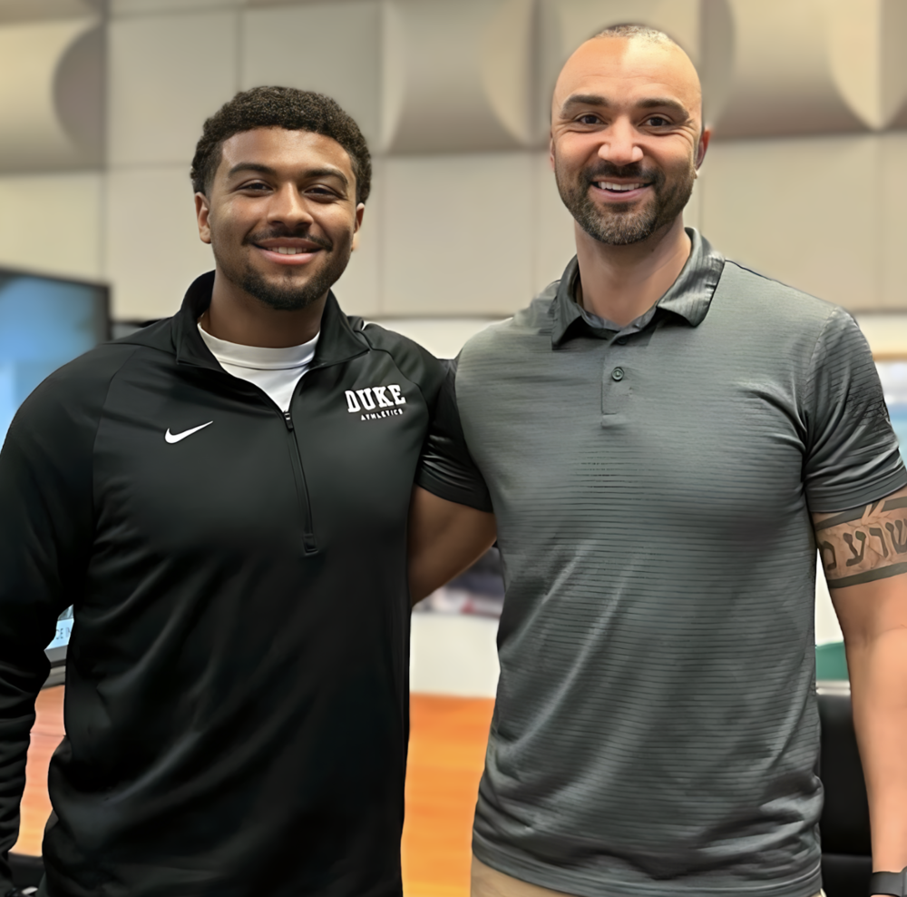 Alumni Darnell LaPlant and his former teacher taking a photo together after he presented to  a Sports Science class.