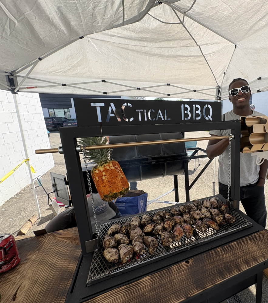 Student smiling pictured next to the smoker he created inspired by his dad.  
