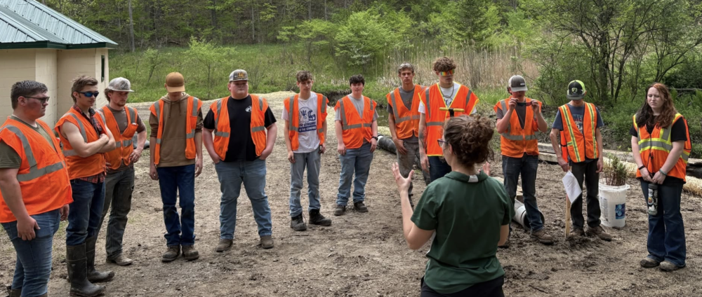 A group of Batavia CTE Conservation and Diesel Technology students stand at the Black Creek restoration site in Genesee County Park & Forest after completing streambank stabilization and habitat restoration work as part of the Healthy Headwaters project.