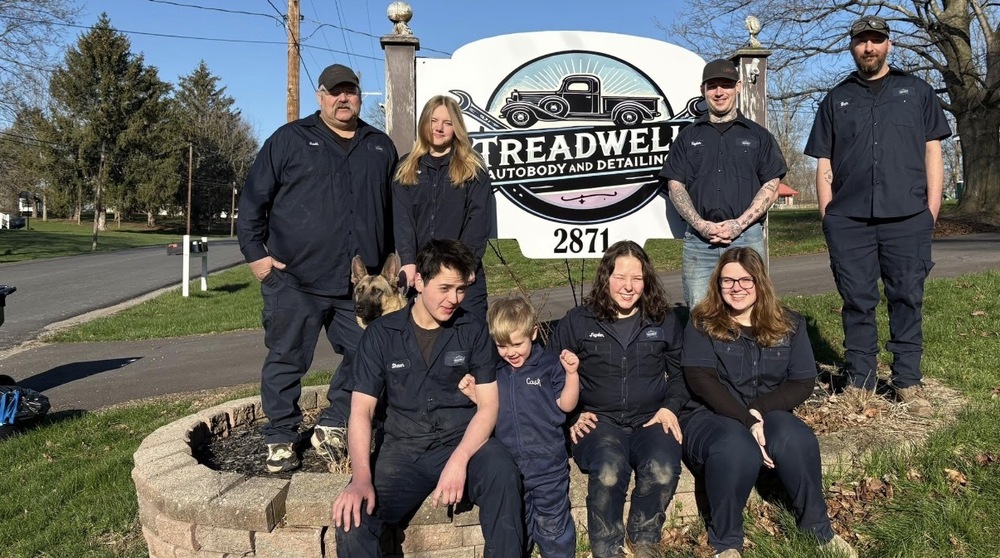 Threadwell Autobody and Detailing workers posing in front of their sign.