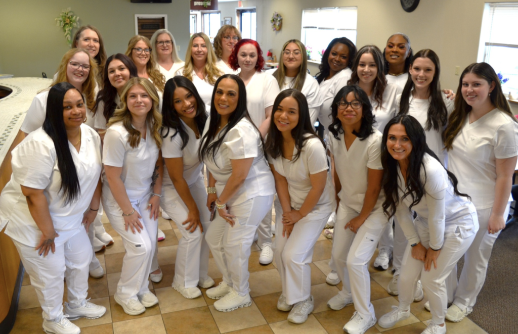LPN Students in their white uniforms gathered together ready to graduate from the program.