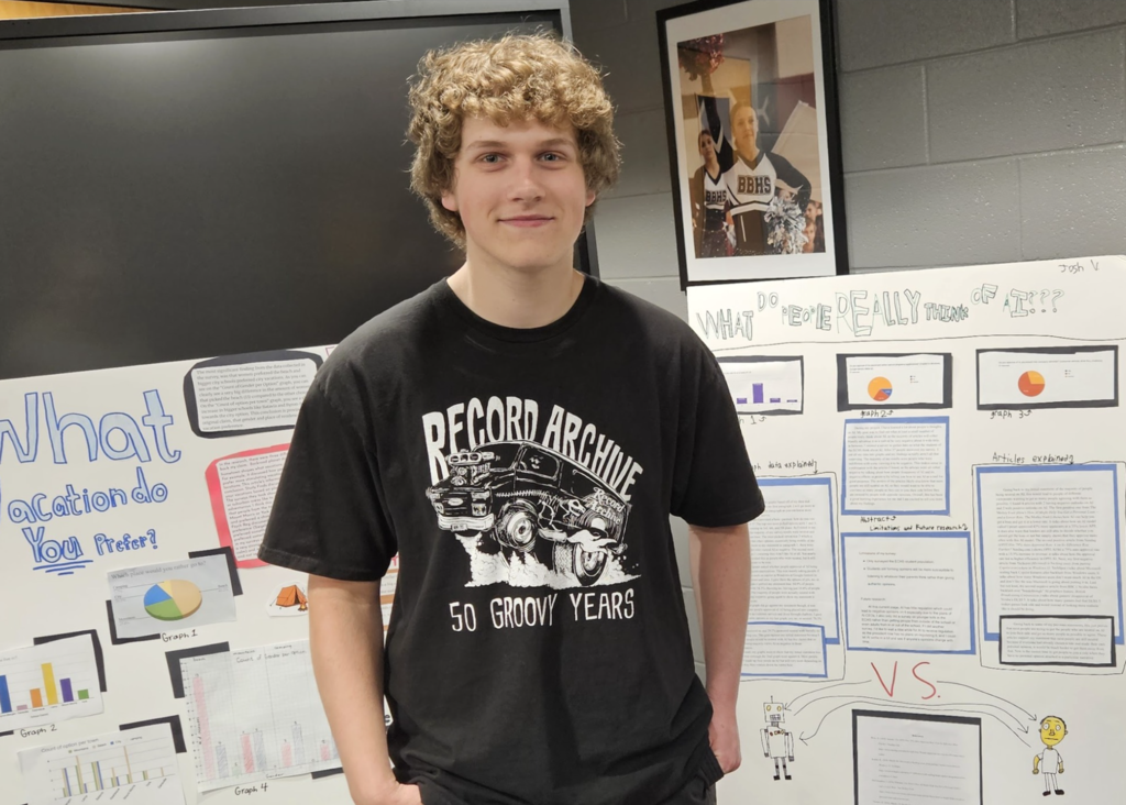 A student standing in front of his research poster.  